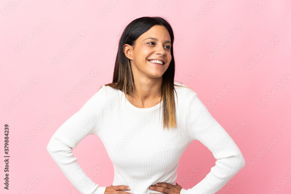 Caucasian girl isolated on pink background posing with arms at hip and smiling Caucasian girl isolated on pink background posing with arms at hip and smiling