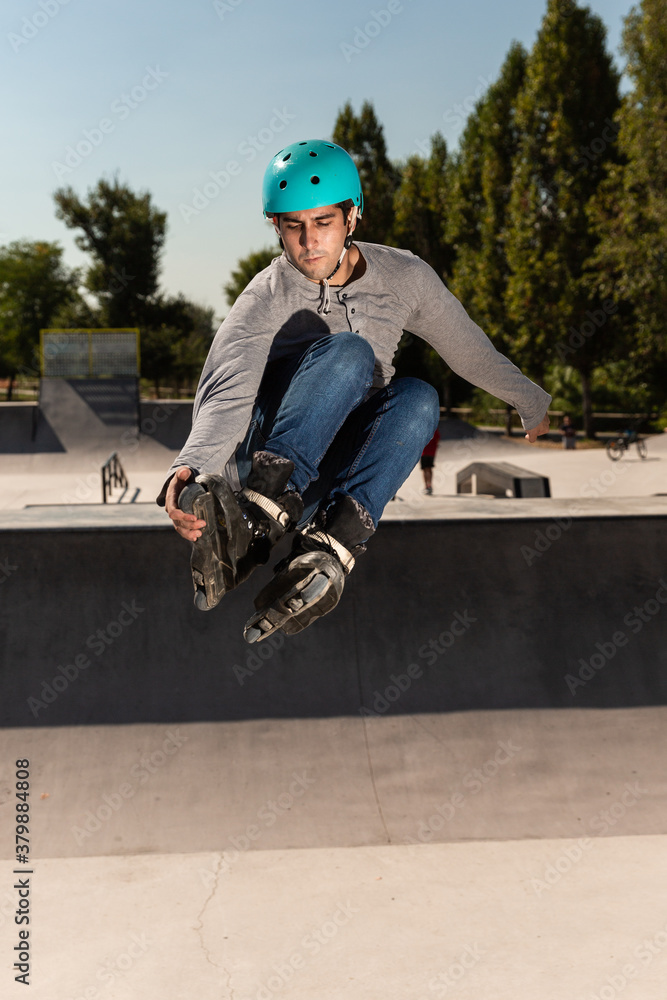 Obraz premium roller guy does a trick in the air in a skate park