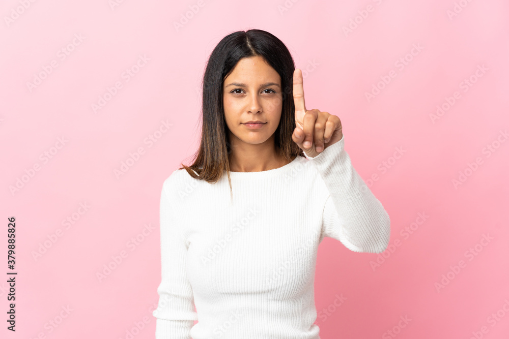 Caucasian girl isolated on pink background counting one with serious expression Caucasian girl isolated on pink background counting one with serious expression