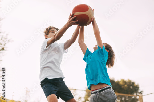 Two teenage boys play basketball on the Playground. Athletes fight for the ball in the game. Healthy lifestyle, sports © Sviatlana