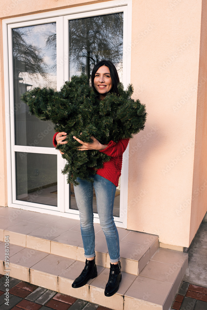 Woman holding imitation Christmas tree Woman holding imitation Christmas tree