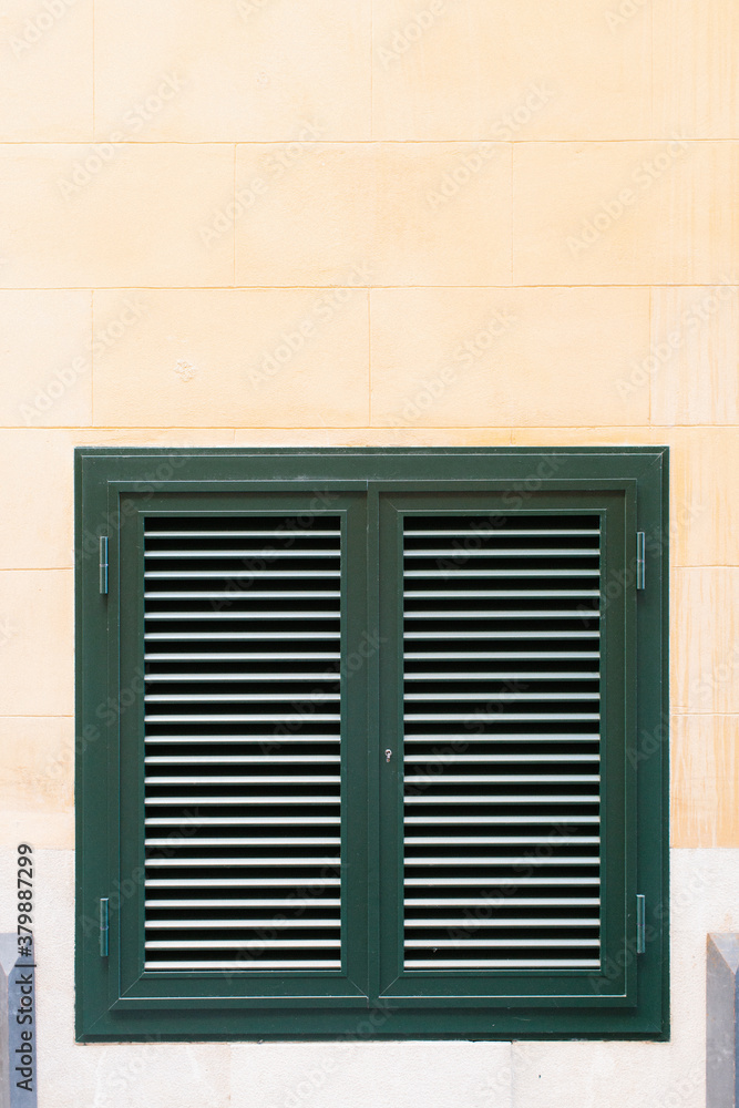 Window with closed wooden green shutters Window with closed wooden green shutters