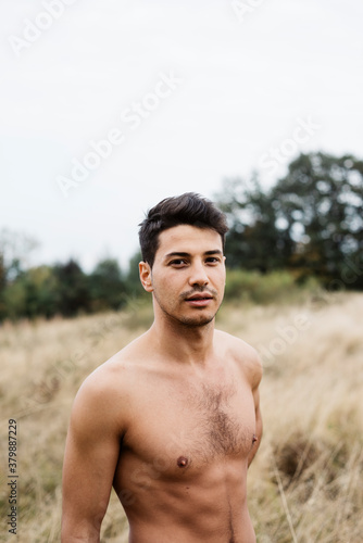 Young Man Shirtless in Field photo