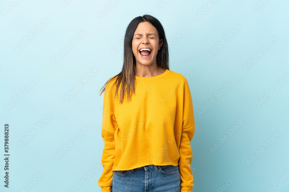 Caucasian girl isolated on blue background shouting to the front with mouth wide open Caucasian girl isolated on blue background shouting to the front with mouth wide open