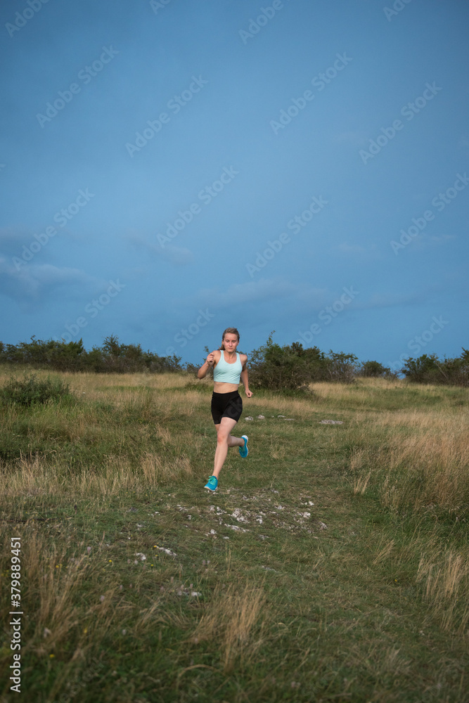 Sportive woman running hard outdoor on a summer day Sportive woman running hard outdoor on a summer day