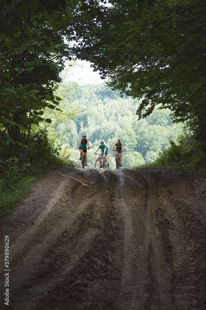 Cyclists ready to go downhill on a muddy trail Cyclists ready to go downhill on a muddy trail