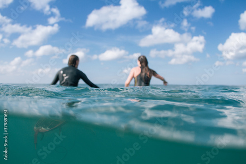 surfers couple sitting waiting together for waves photo