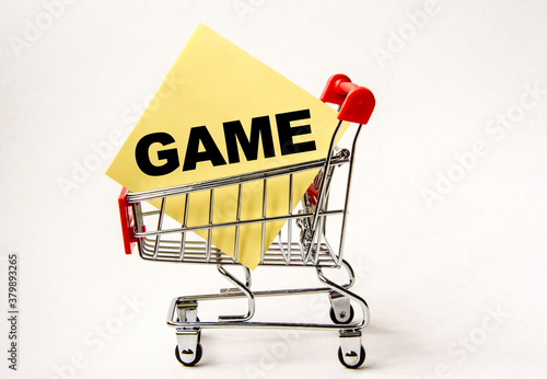 Shopping cart and text game on yellow paper note list. Shopping list, business concept on white background.