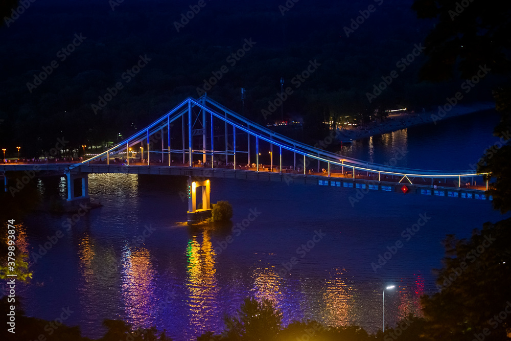 Night view of Pedestrian bridge over Dnieper river in Kyiv, Ukraine. July 2020