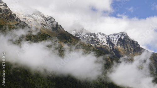 View of Corno Bussola (Valle d'Ayas, AO) surrounded by clouds and covered by snow after a storm in august