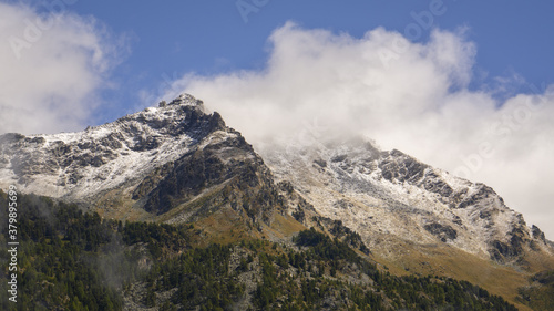 Titolo: View of Corno Bussola (Valle d'Ayas, AO) surrounded by clouds and covered by snow after a storm in august.