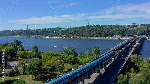 Wallpaper Mural Drone flying pathing  to direction to Pecherskaya Lavra and Motherland statue above Dnepr river and Metro bridge with driving cars and trains. Aerial view to a beautiful  Kiev city in summer Ukraine.  Torontodigital.ca