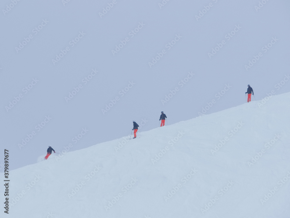 Skiers descending a ski slope on a cold winter day