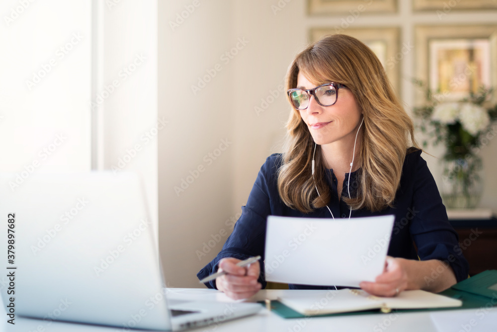 Smiling businesswoman having web conference while working from home Smiling businesswoman having web conference while working from home