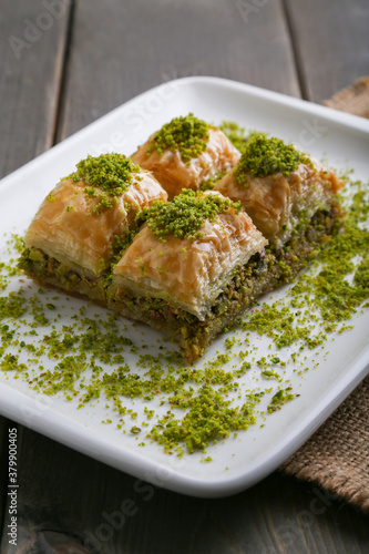 Baklava with pistachio on a white plate close up vertical view