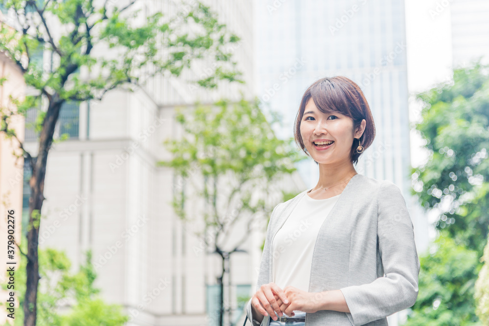 オフィス街で微笑む若い女性 オフィス街で微笑む若い女性