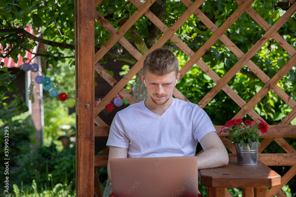 Young smart freelancer working outdoors with laptop, confident man in earphones talking by video conference, male student sits on terrace watching webinar. Concept of online education, remote work