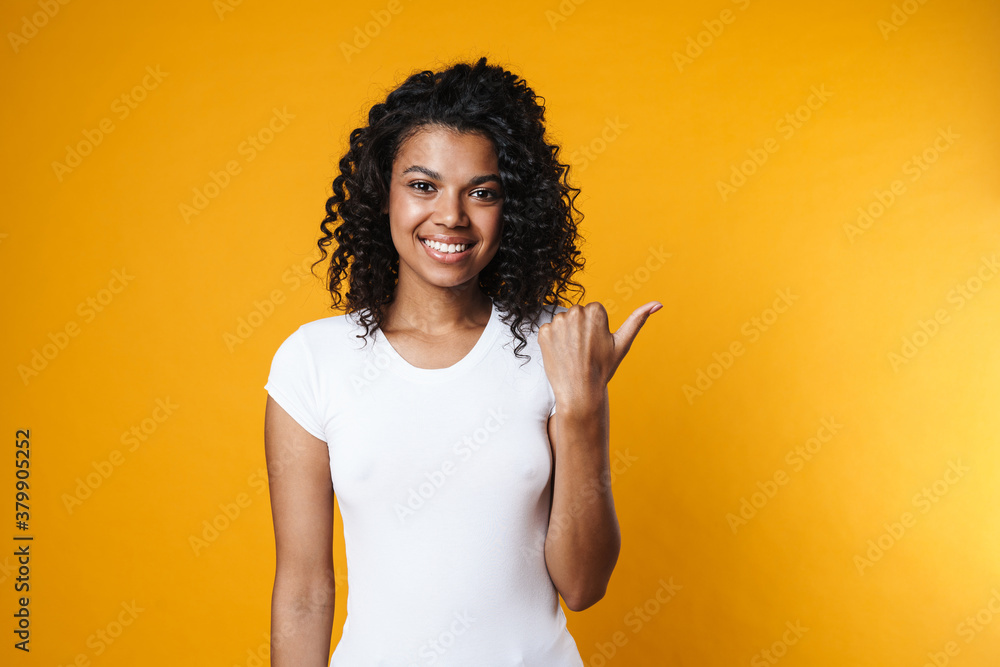 Image of cheerful african american woman pointing finger aside Image of cheerful african american woman pointing finger aside