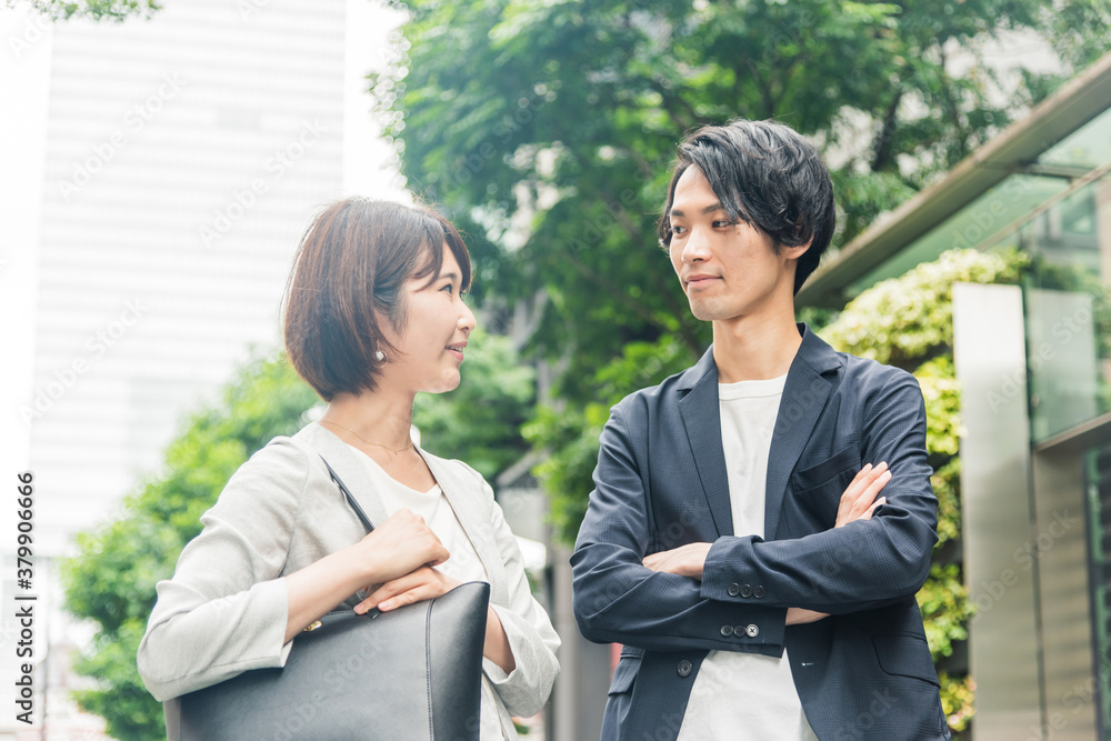 オフィス街で会話する男女 オフィス街で会話する男女