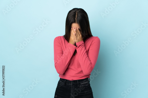 Teenager girl isolated on blue background with tired and sick expression