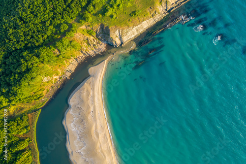 Beautiful view of a sandy beach surrounded by sea waves on one side and on the other by the waters of a river that flows into the sea  the mouth of Veleka River at the Black sea coast  Bulgaria