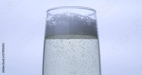 Pouring champagne into a glass on a black background	 photo