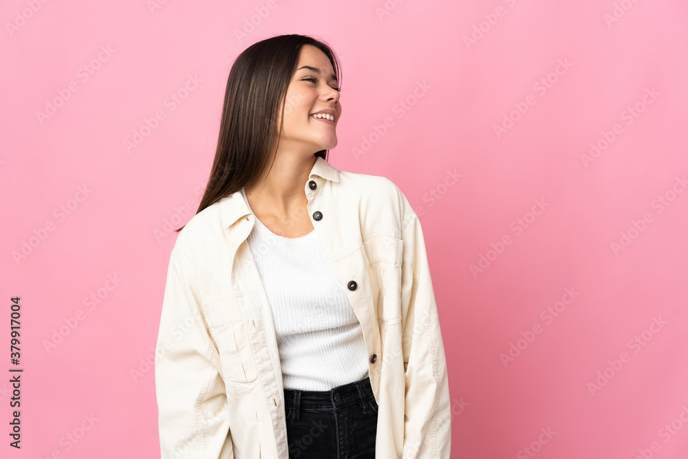 Teenager girl isolated on pink background looking to the side and smiling Teenager girl isolated on pink background looking to the side and smiling