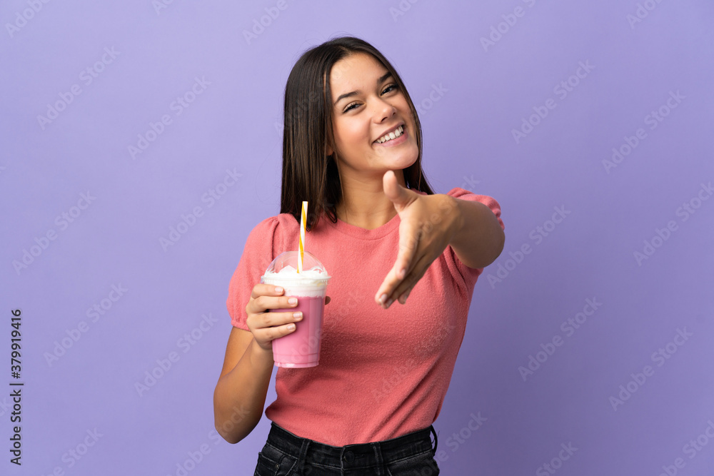 Teenager girl holding a strawberry milkshake shaking hands for closing a good deal Teenager girl holding a strawberry milkshake shaking hands for closing a good deal