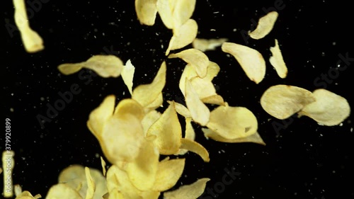 Super slow motion of flying fried potatoes chips hitting up in the air. Filmed on high speed cinema camera, 1000 fps. photo
