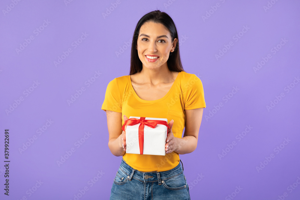 Happy woman holding gift box at studio Happy woman holding gift box at studio