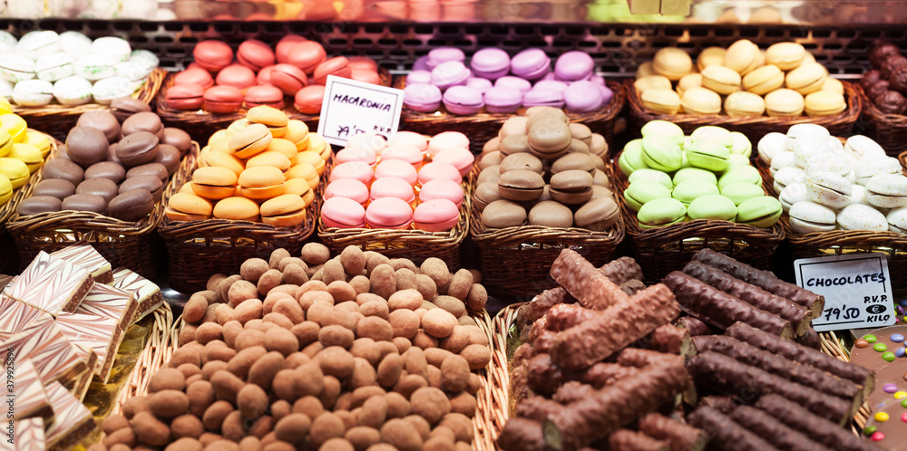 french macarons and other sweets on counter of market