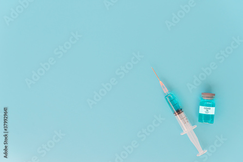 A concept of against virus covid-19 corona virus, a syringe with liquid vaccines and with blue background. Top view.