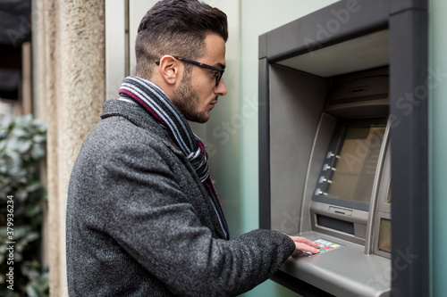 Man taking money from Cash Machine photo