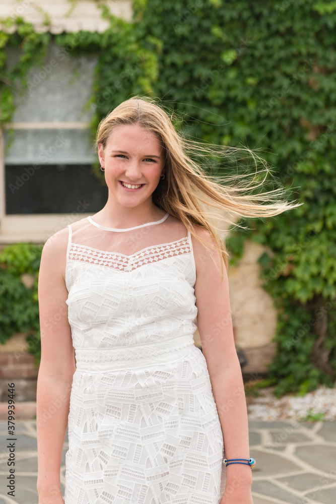 pretty teen girl in white dress with hair blowing in the wind pretty teen girl in white dress with hair blowing in the wind