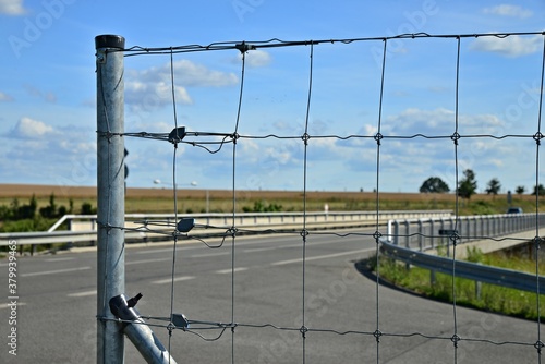 End of fencing at the highway overpass. Protection of a large intersection. Steel fence by the highway. Highway bridge, junction, protective barrier.
