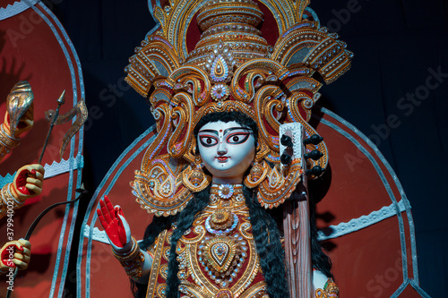 Goddess Saraswati idol , Durga Puja festival at night. Shot under colored light at Howrah, West Bengal, India. Biggest festival of Hinduism , celebrated all over the world. photo