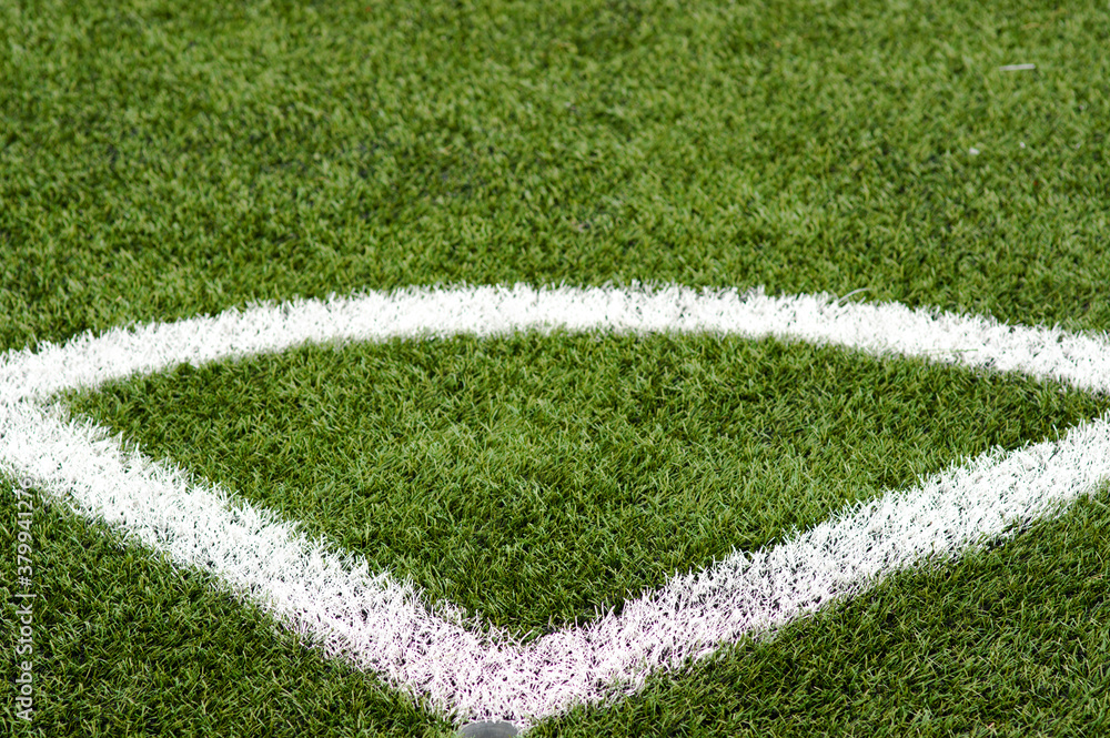 White border stripes on green artificial grass of a football field