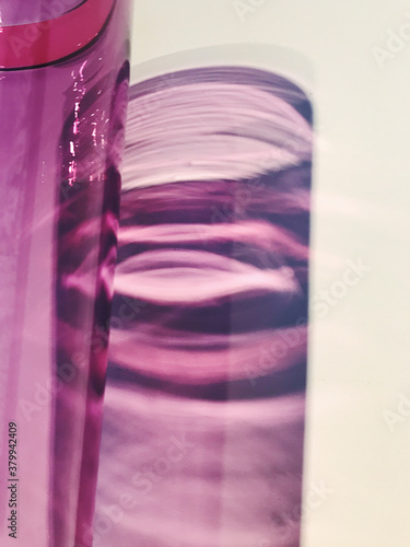 Close up of handmade purple glass vase, casting purple shadow photo