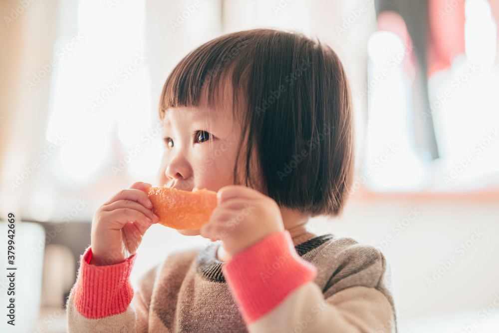 baby girl eating orange