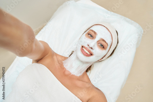 Portrait of moisturizing mask on white background for medical design. Woman skin procedure. Natural cosmetic products. Beauty face. Facial cosmetology treatment. Healthcare. Selfie at spa center