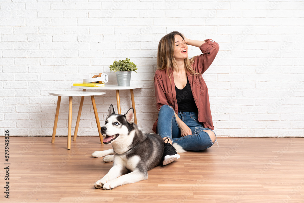 Young girl with her dog sitting in the floor at indoors has realized something and intending the solution Young girl with her dog sitting in the floor at indoors has realized something and intending the solution