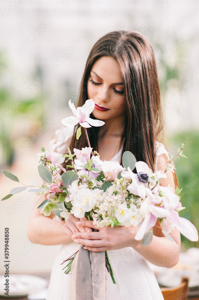Long-haired brunette girl holds a flwers bouquet Long-haired brunette girl holds a flwers bouquet
