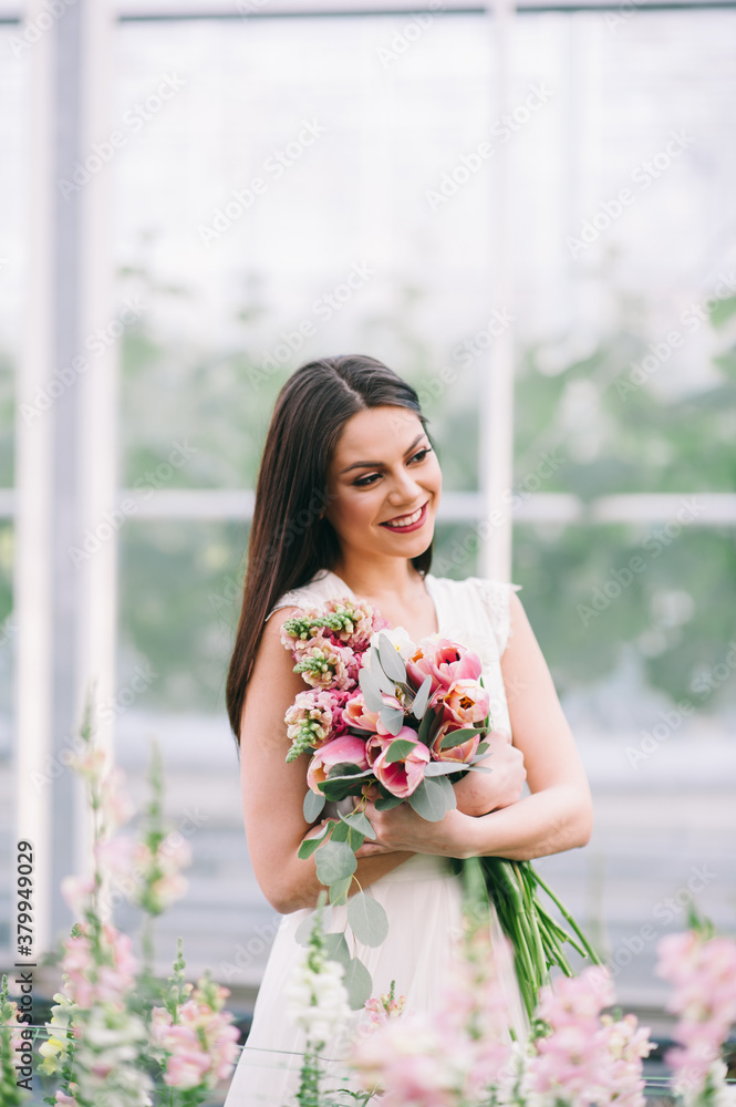 Long-haired brunette girl holds a flwers bouquet Long-haired brunette girl holds a flwers bouquet