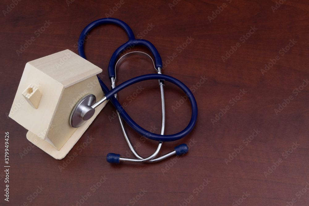 Checking, testing and repairing house concept, healthy house theme. Stethoscope and small wooden house with copy space Checking, testing and repairing house concept, healthy house theme. Stethoscope and small wooden house with copy space