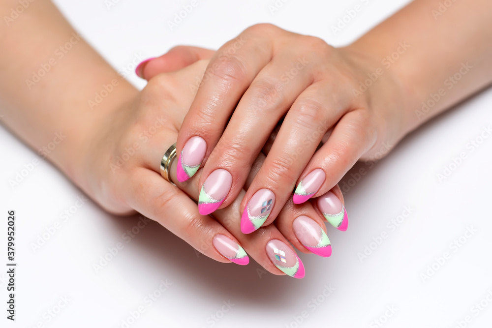 Pink mint French manicure with silver rhombuses on sharp long nails close-up on a white background. Gel lay-out manicure.