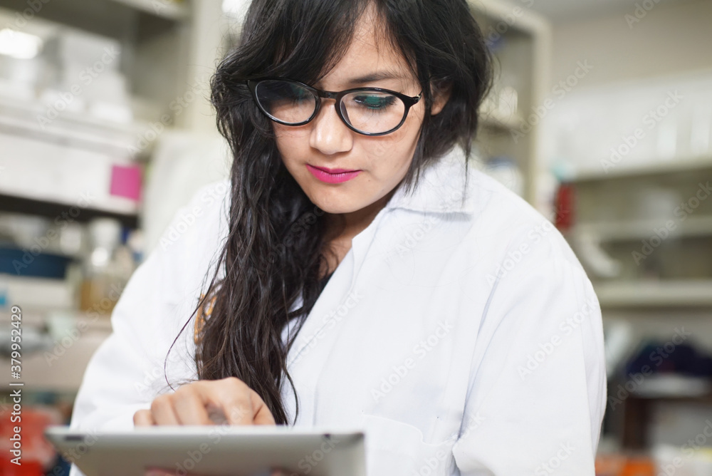 Female scientist using digital tablet in laboratory. Female scientist using digital tablet in laboratory.