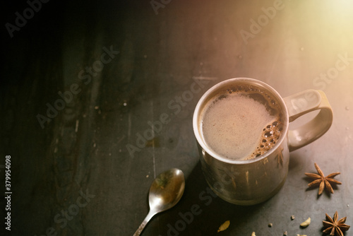 metal thermo mug with coffee on a gray background with star anise and cardamom