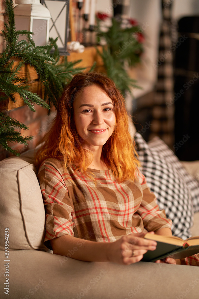 A cute girl is reading a book in a warm and cozy atmosphere. Relaxation and privacy concept A cute girl is reading a book in a warm and cozy atmosphere. Relaxation and privacy concept