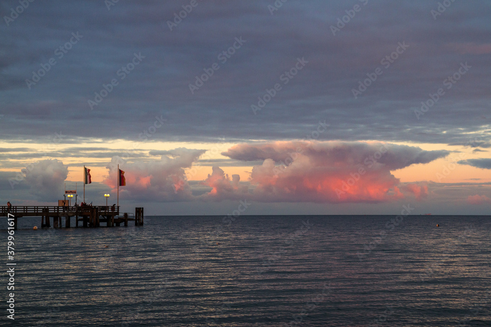 jetty in front of clouds by the sea