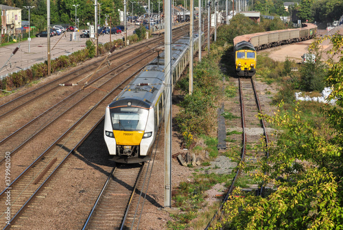 Southbound passenger train passes freight in Hitchin goods yard photo